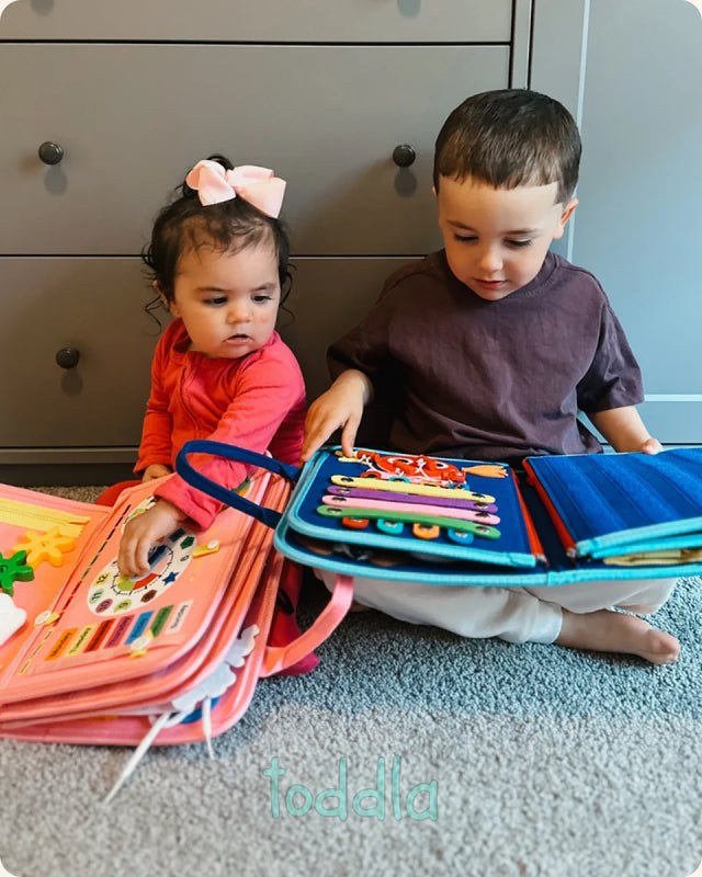 Toddler working through activities on the Toddla Montessori Busy Board